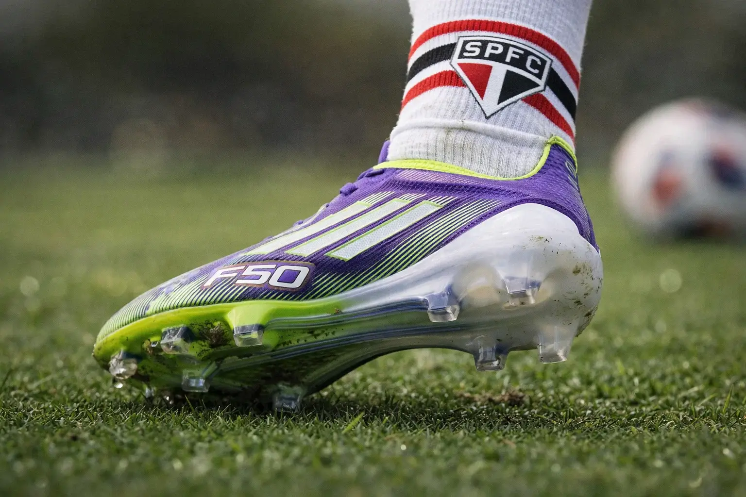 Chuteira FG no gramado natural — como escolher travas e ajuste Close de chuteira FG em gramado natural mostrando travas firmes e apoio do pé.