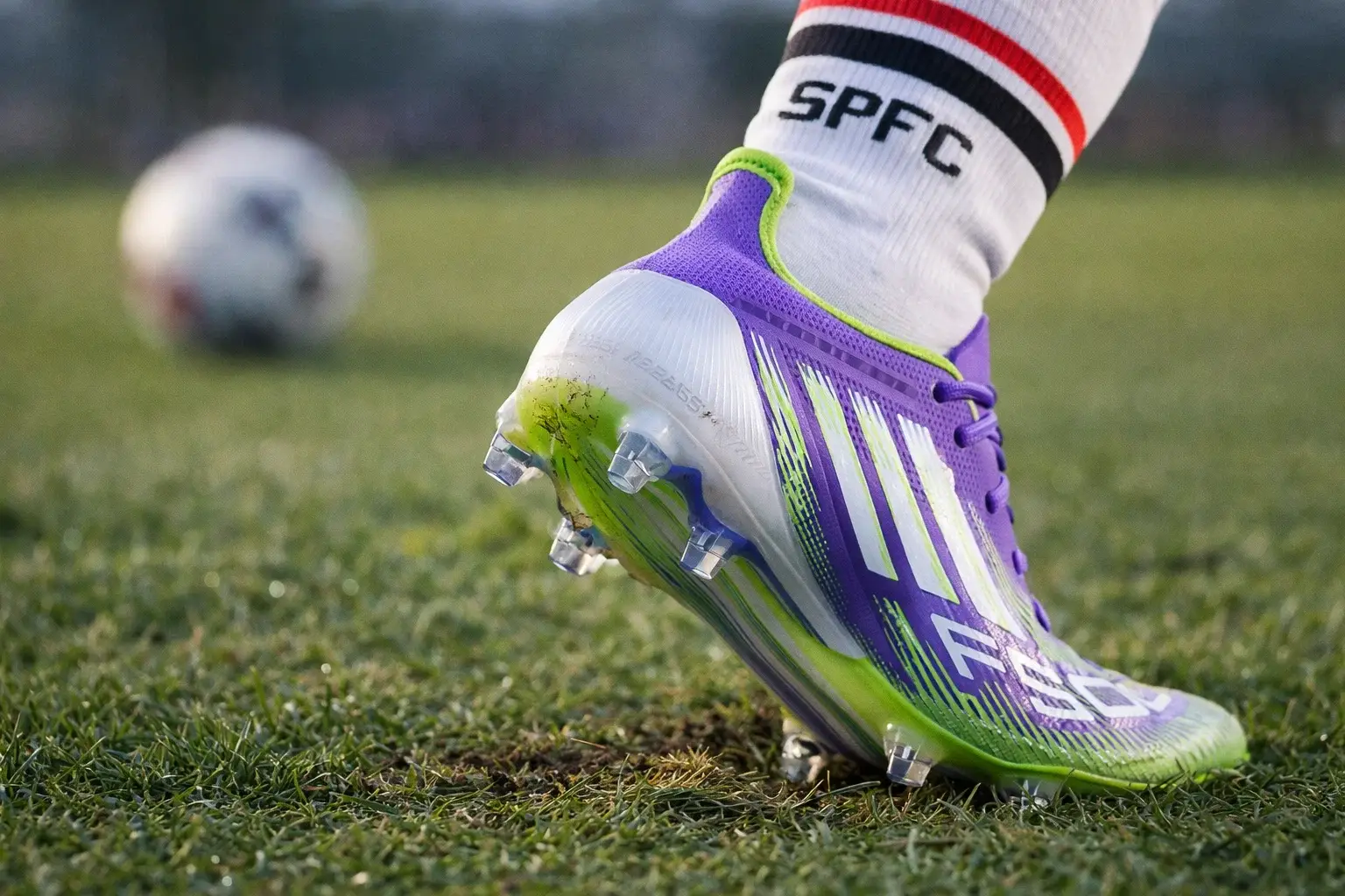 Chuteira Adidas F50 (Elite/Pro FG) — Melhor Geral Atleta grudado no gramado natural com chuteira Adidas F50 em foco