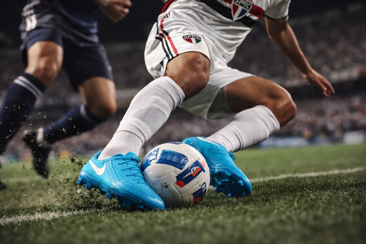 Chuteira Phantom Gx para armadores e dribladores — condução curta e corte rápido Armador driblando no gramado natural com chuteira Nike Phantom Gx em destaque, bola colada no pé e corte rápido para criar jogada (imagem 4:3)